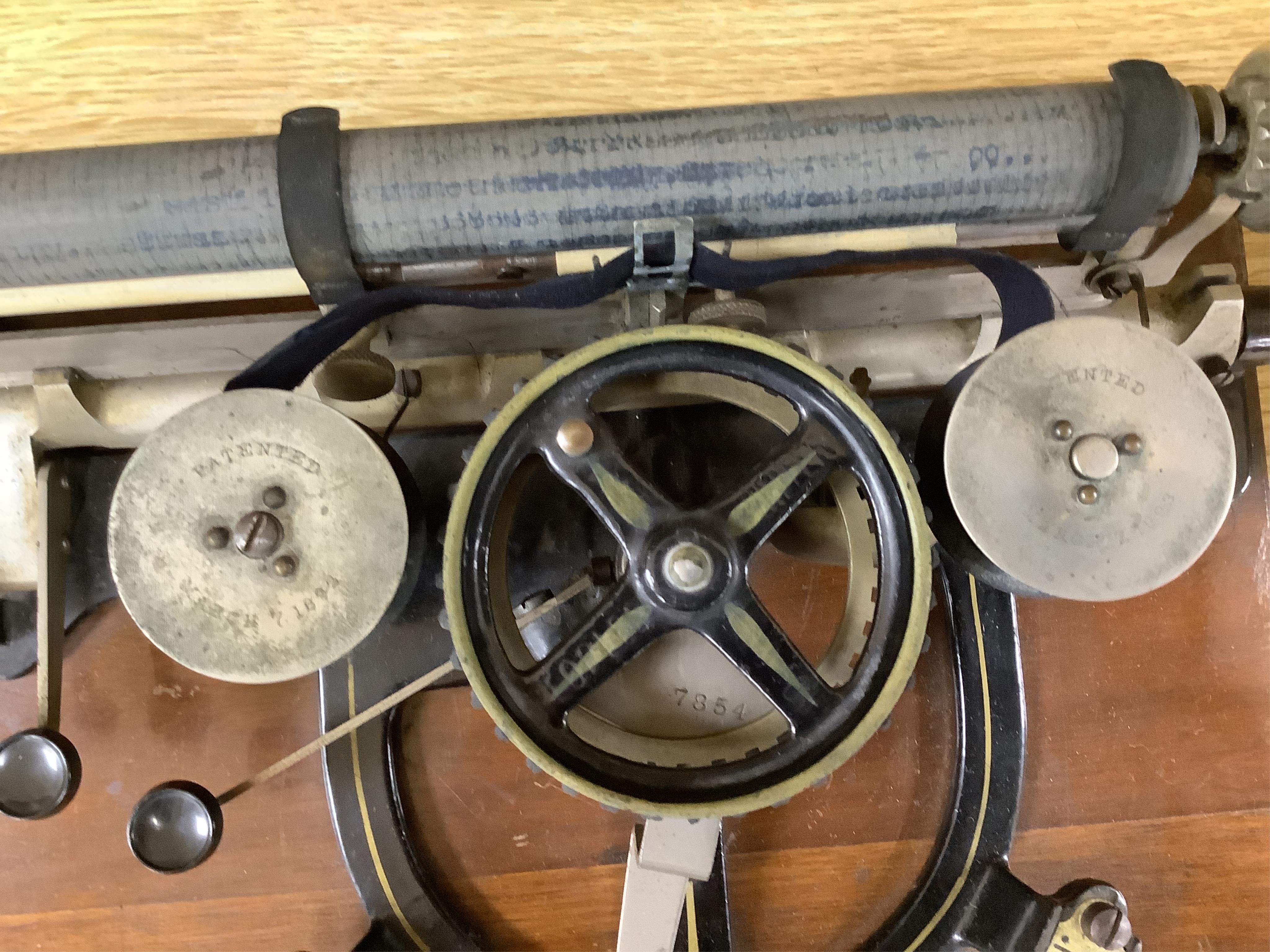 A Peoples Champion Indexing Typewriter, circa 1893, by the Garvin Machine Co., New York, on a mahogany plinth, with black tin cover, inscribed ‘’PEX’’ CHAMPION, width 28cm; a Bar-Let vintage typewriter, cased; an Underwo